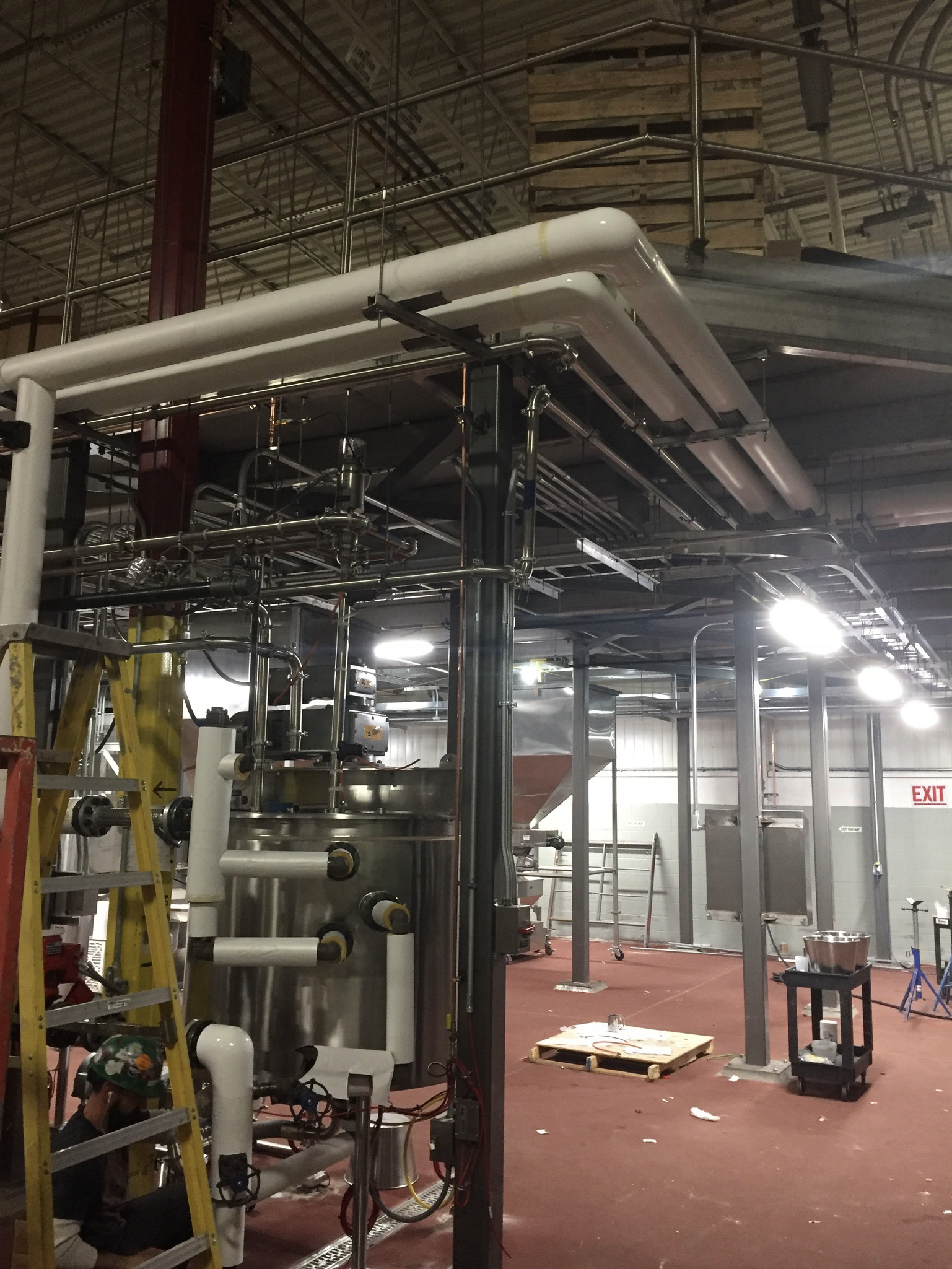 Process piping and insulated hot oil lines installed around mixing tanks for caramel popcorn manufacturing system