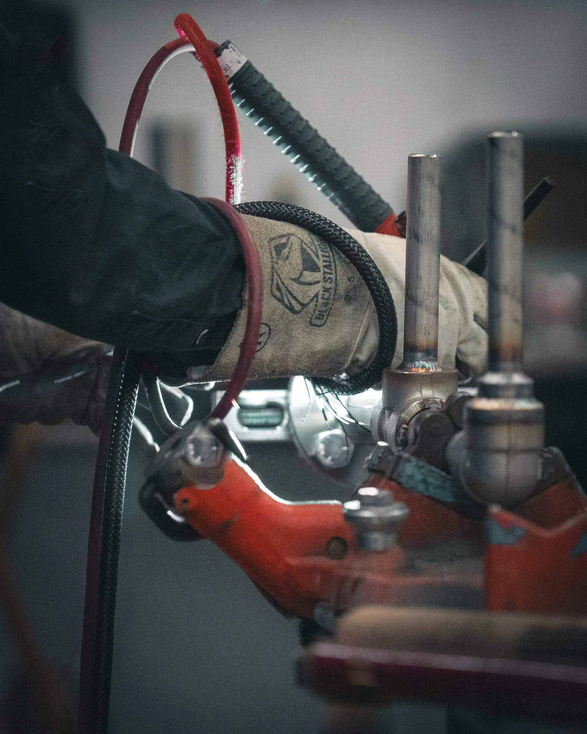Worker welding a pipe connection inside an industrial facility