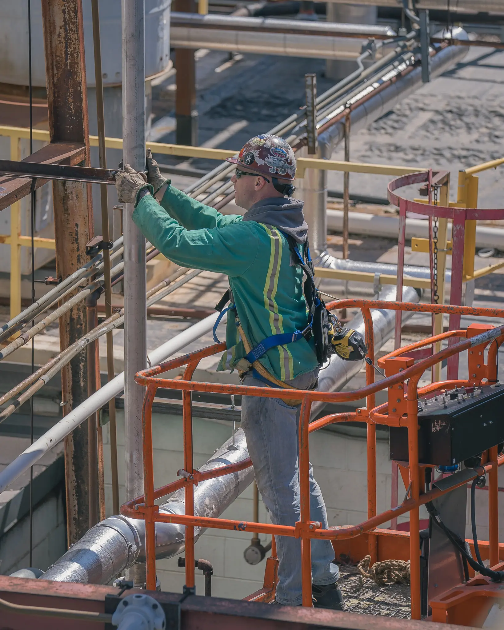 Pipefitter working from a lift platform during an industrial shutdown piping project