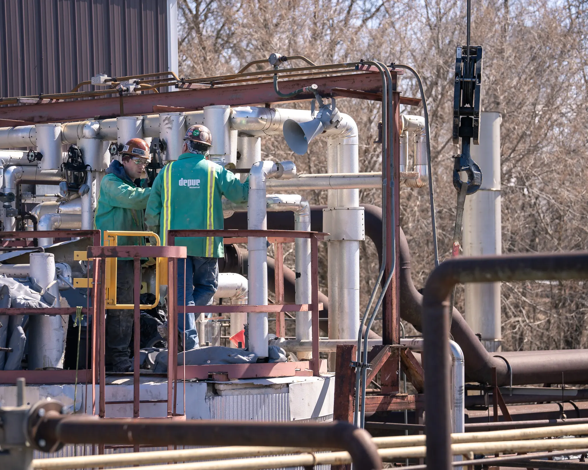 Mechanical crew working on skid-mounted piping and process equipment at an industrial facility