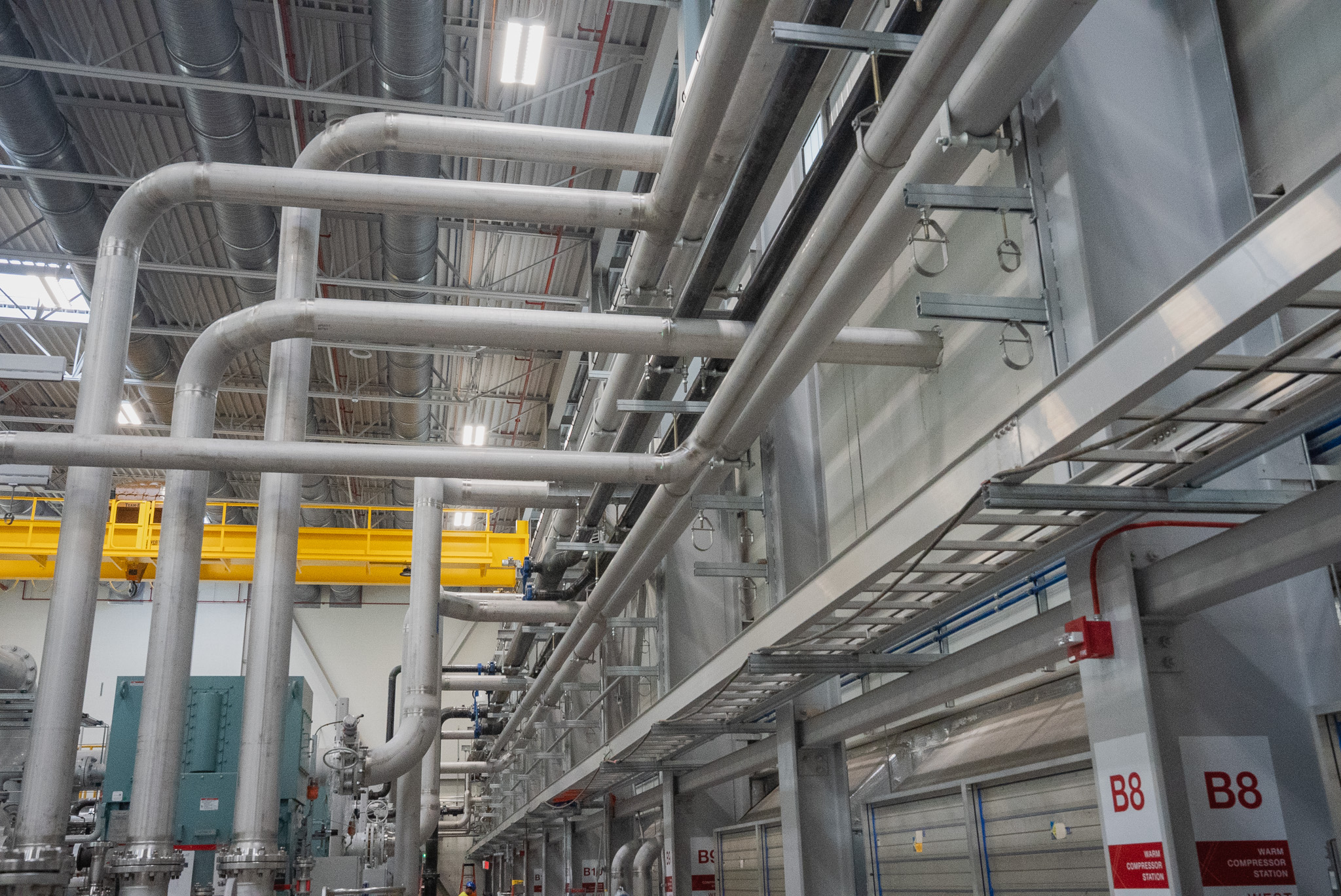 Overhead industrial utility piping and cable tray inside a manufacturing facility